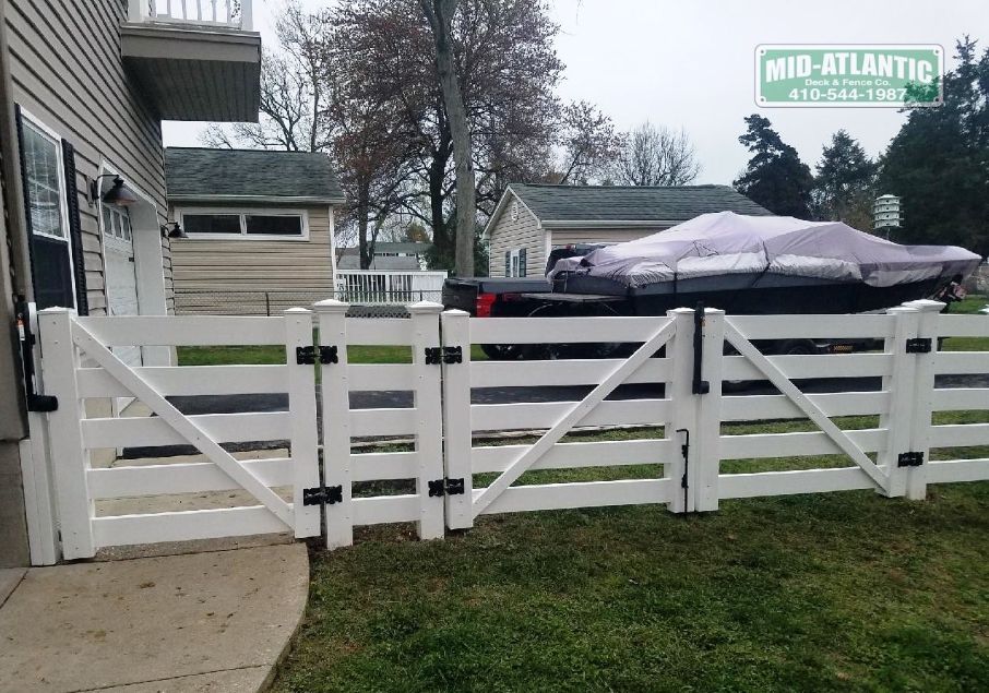 White vinyl 5 rail paddock style fence single gate for the sidewalk and a double drive gate for the boat. Anne Arundel County Maryland.