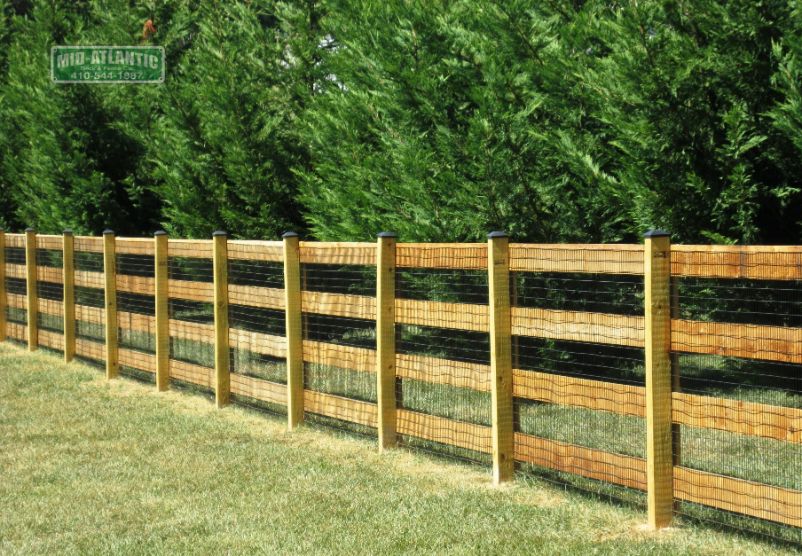 4-rail paddock style wood fence with the attachment of 2”x 4” black vinyl coated welded wire mesh in Sykesville Maryland.