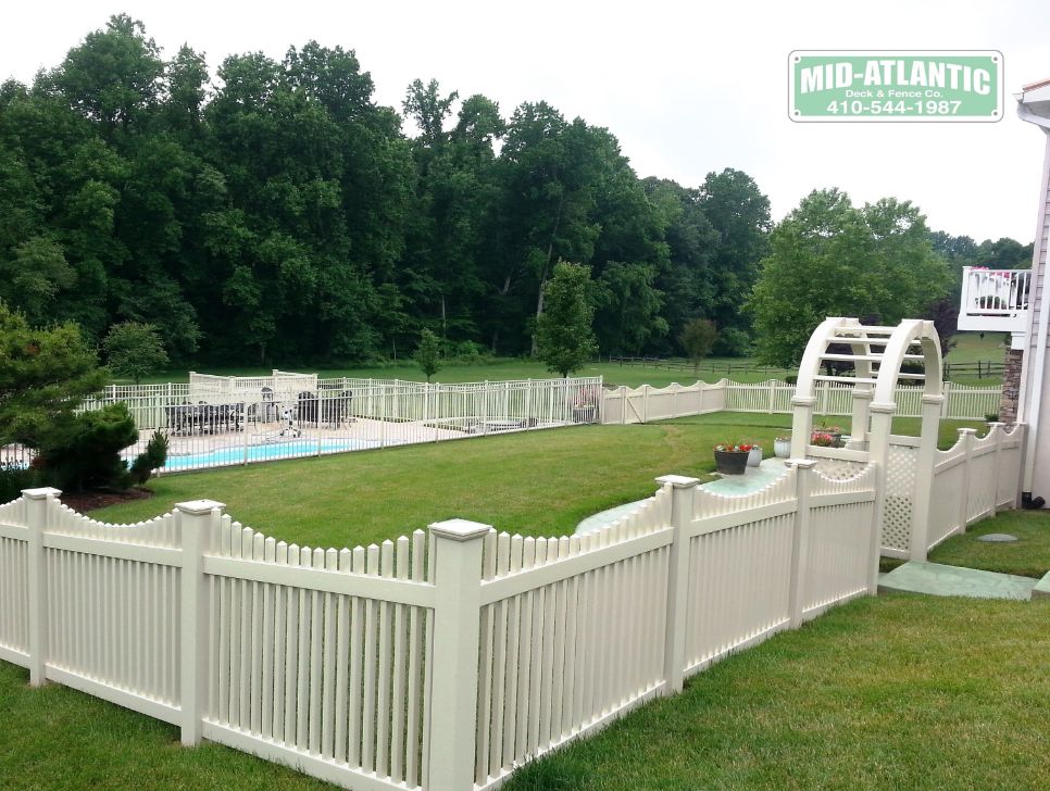 Can’t say enough about this project. It’s our tan vinyl Oxford picket with a custom arched top arbor and notice the 3-rail ornamental aluminum fence around the inground pool. Located in Stevensville Maryland.