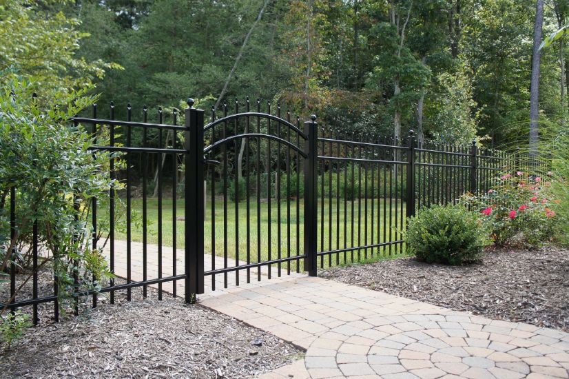 Notice how the pickets go through the top rail on this black 3-rail aluminum fence. Add an arched top gate to finish it off.