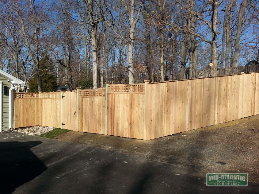 Stair stepped vertical board style fence with square lattice top. Transitioning to a 6’ tall solid board privacy fence.