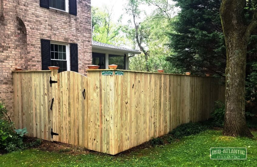 Wood fence is still our favorite. This pressure treated vertical board style with federal style post caps and round top gate was the favorite of this customer in Crownsville Maryland.