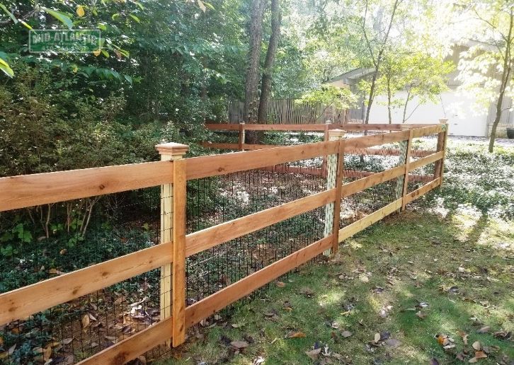 Mid Atlantic’s 3 rail paddock style wood fence in Annapolis Maryland using pressure treated posts, cedar horizontal rails, black vinyl coated welded wire mesh and cedar pyramid style post caps.