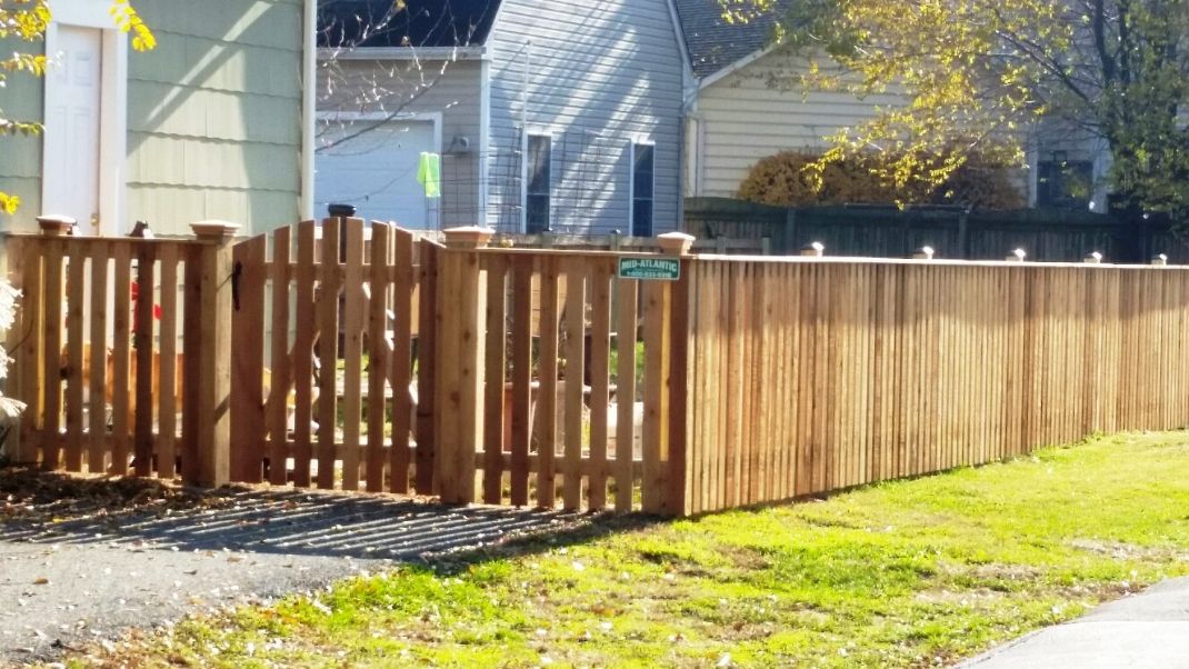 Cedar federal style post caps and the arched top cedar picket gate was a great option for this picket style fence with cap board in Mayo Maryland.