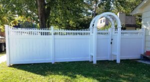 white vinyl privacy fence with arbor over gate, bluish tint