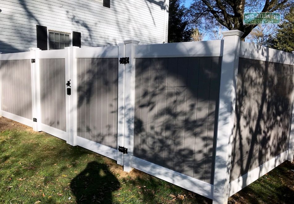 Here we go again, Chesterfield vinyl privacy fence with white frame and gray slats. Double drive gates allow easy access to your back yard.