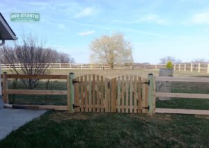 3-Rail paddock style wood fence with a picket style arched top double drive gate in Clarksville Howard County Maryland.